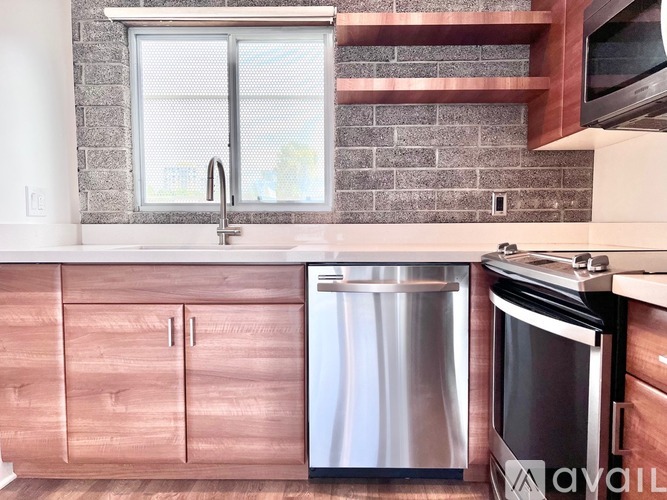 A kitchen with a stainless steel dishwasher and oven.