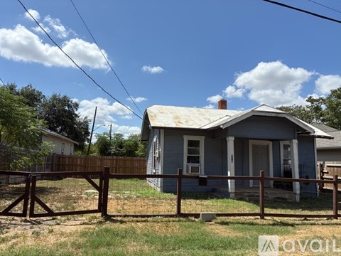 A small house with a fence in front of it.