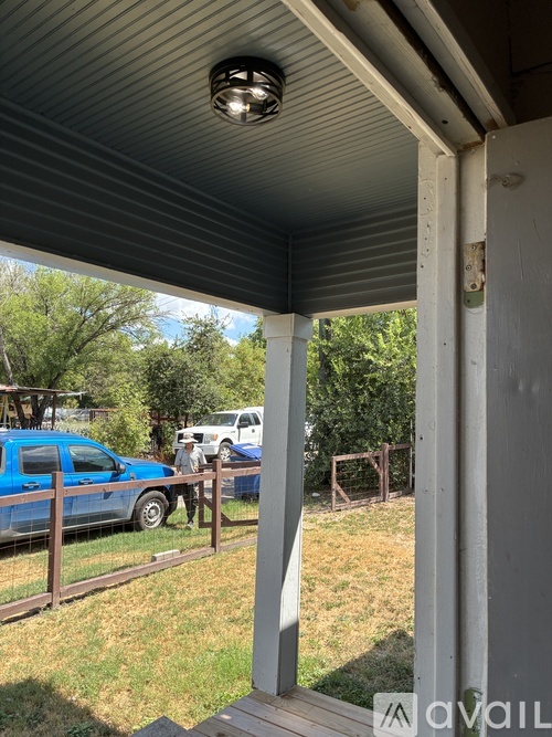 A blue car is parked in a driveway.