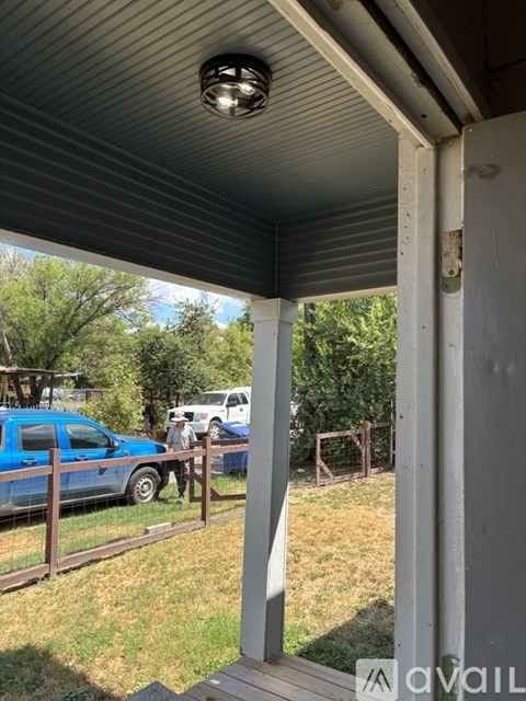 A blue car is parked in a driveway.