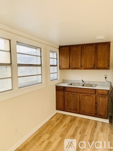 A kitchen with wooden cabinets and a sink under a window.