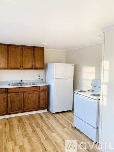 A kitchen with wooden cabinets and a white fridge.