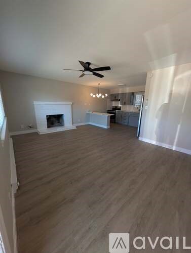 A living room with a fireplace and a ceiling fan.