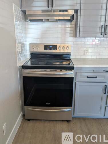 A modern kitchen with a stainless steel oven and a white dishwasher.