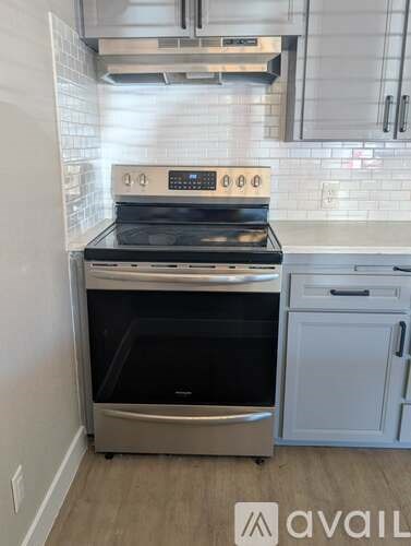 A modern kitchen with a stainless steel oven and a white dishwasher.