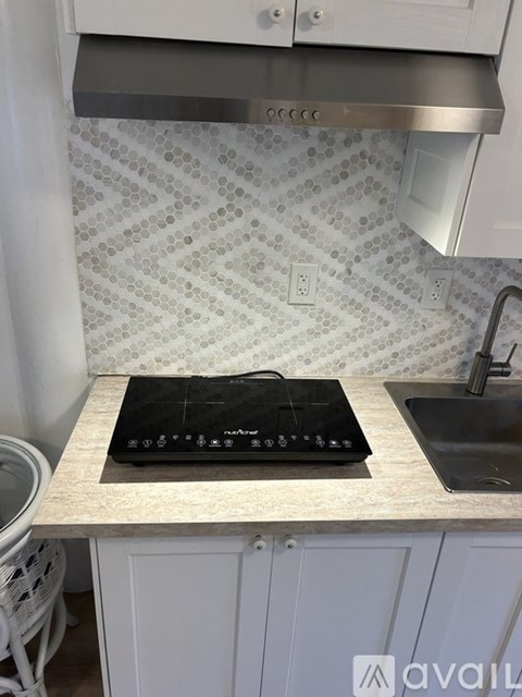 A black induction cooktop is installed on a kitchen counter.
