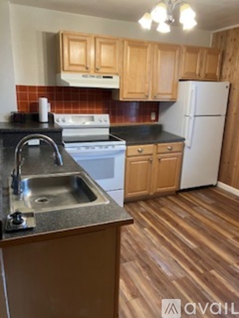 A kitchen with wooden cabinets and a white refrigerator.