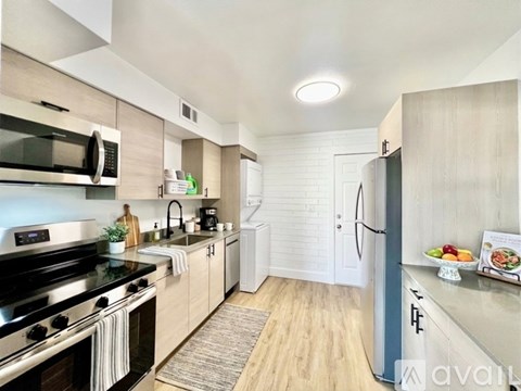 A kitchen with a black stove top oven and a black microwave above it.