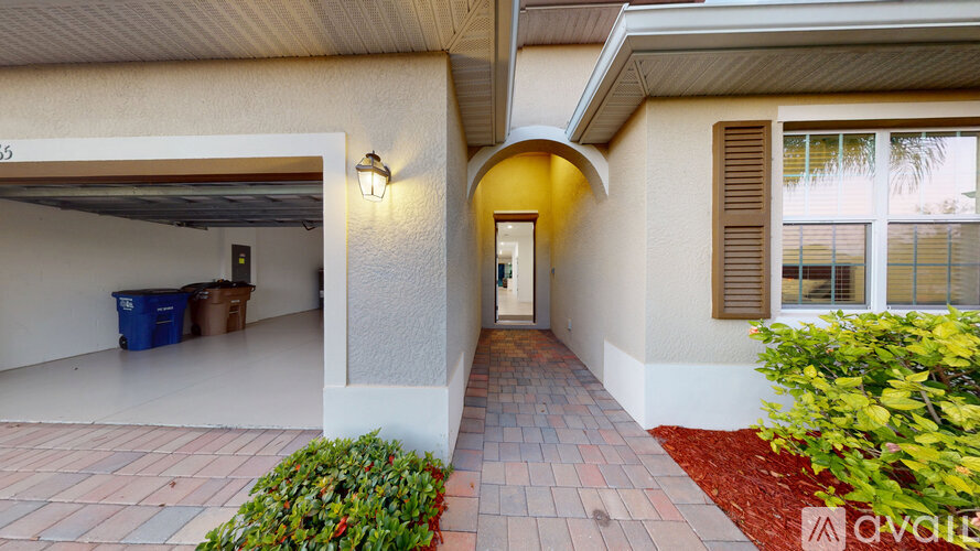 A house with a red brick walkway leading to a white door.
