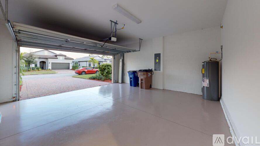 A spacious garage with a red car visible through the open door.