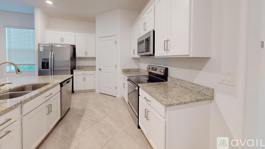 A kitchen with white cabinets and granite countertops.