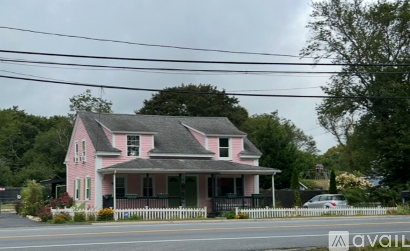A pink house with a black fence in front of it.