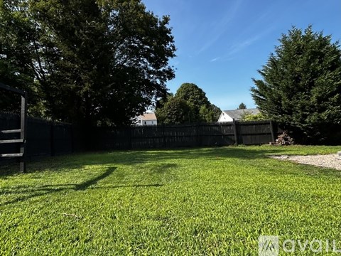 A backyard with a fence and trees.