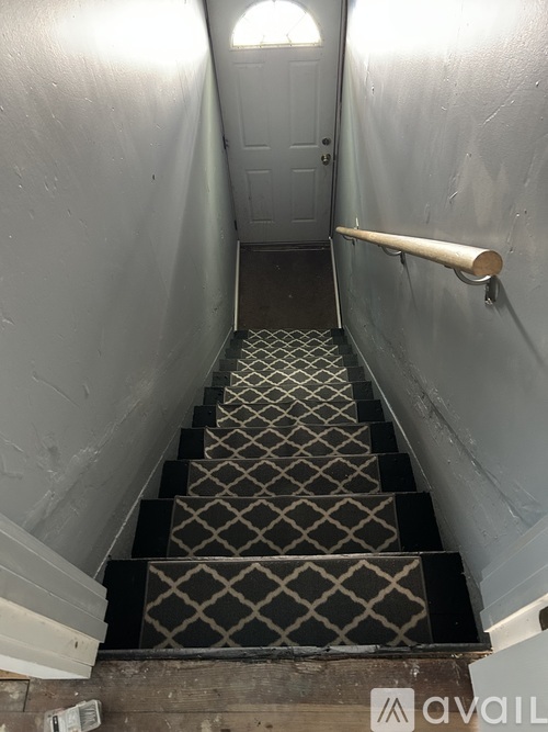 A staircase with a diamond patterned tread and a white handrail.