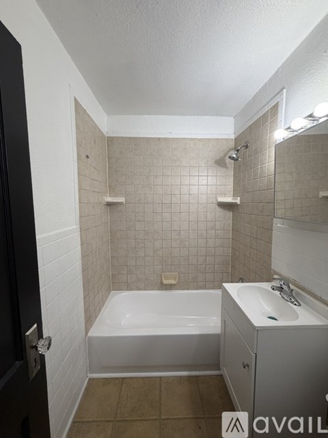 A bathroom with a white tub and sink.