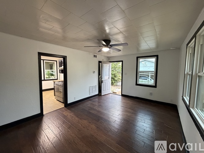 A room with wooden floors and a ceiling fan.
