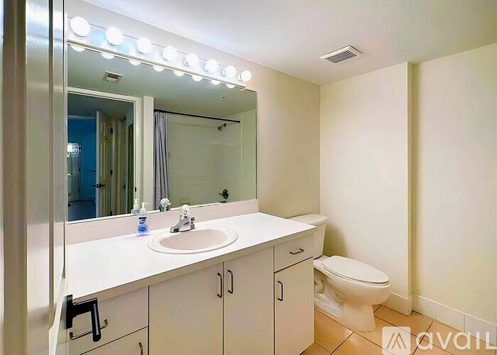 A bathroom with a sink, toilet, and mirror.