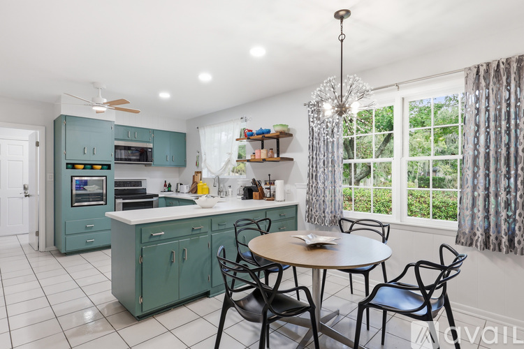 A kitchen with a table and chairs by a window.