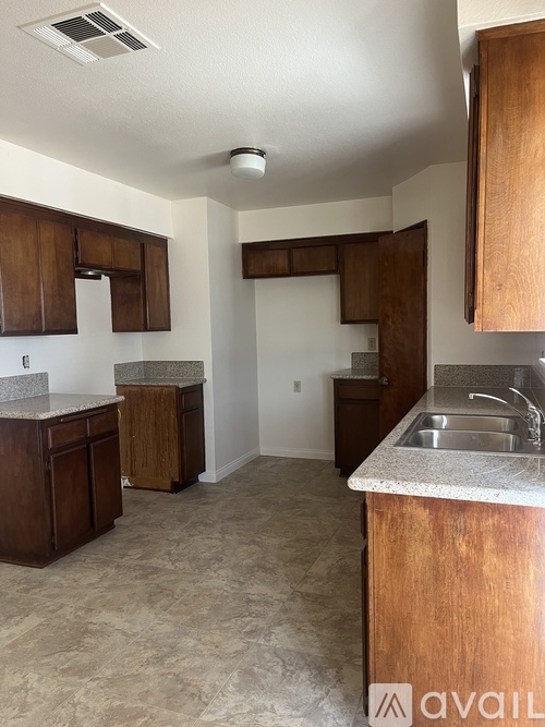 A kitchen with wooden cabinets and a granite countertop.