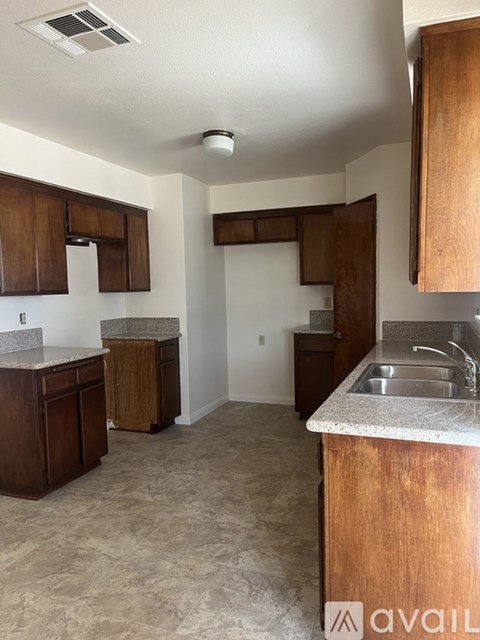 A kitchen with wooden cabinets and a granite countertop.