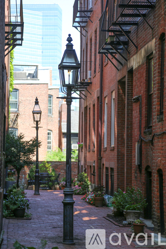 A narrow alley with brick buildings and a lamp post.