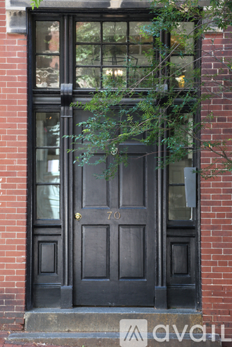 A black door with a gold handle and a number 70 on it.