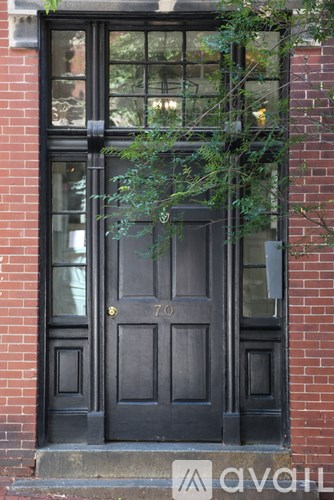 A black door with a gold handle and a number 70 on it.