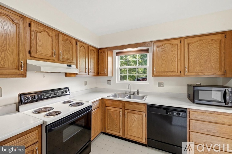 A kitchen with wooden cabinets and a black stove top oven.