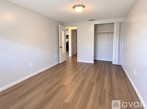 A long hallway with wood floors and white walls.