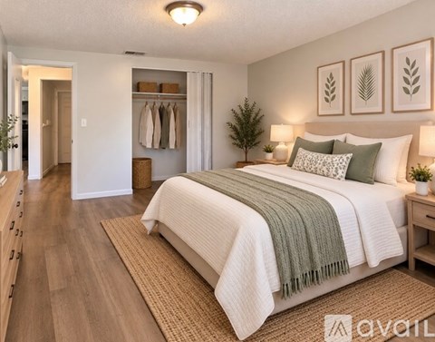 A bedroom with a bed, nightstand, and a wall hanging.