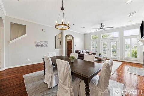 A dining room with a wooden table and chairs.