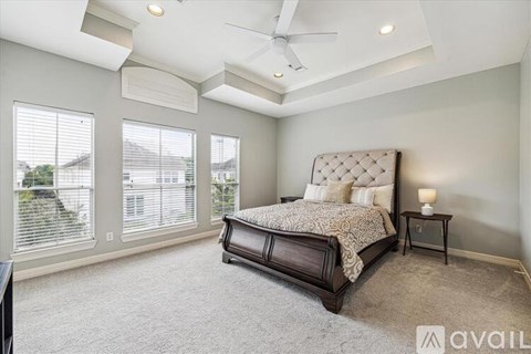 A bedroom with a large bed and a ceiling fan.