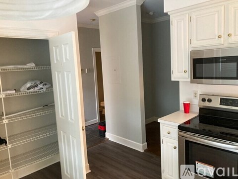 A kitchen with white cabinets and a black oven.