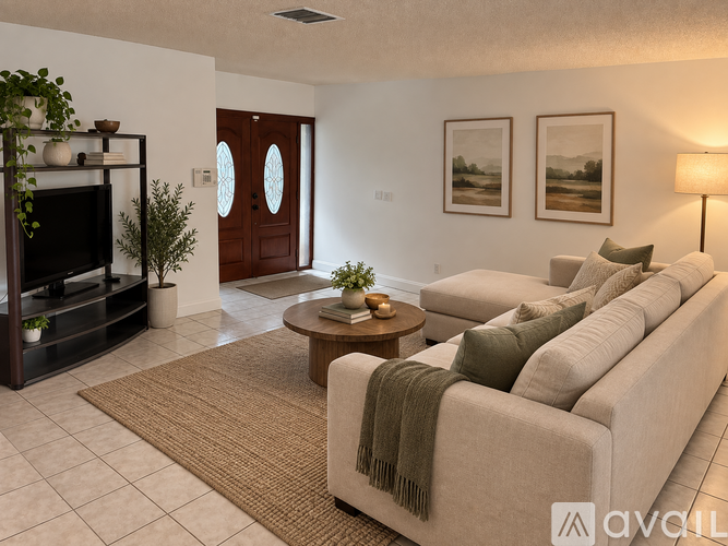 A living room with a couch, a coffee table, a television, and two framed pictures on the wall.