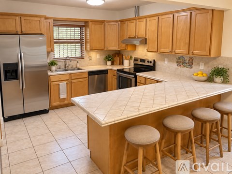 A kitchen with wooden cabinets and a white island.