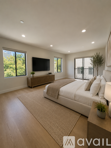 A modern bedroom with a large bed and a flat-screen TV mounted on the wall.