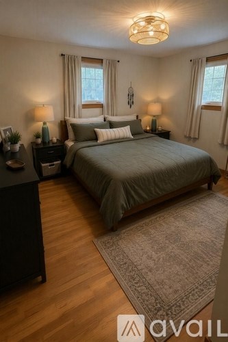 A bedroom with a large bed and two lamps on either side of the bed.