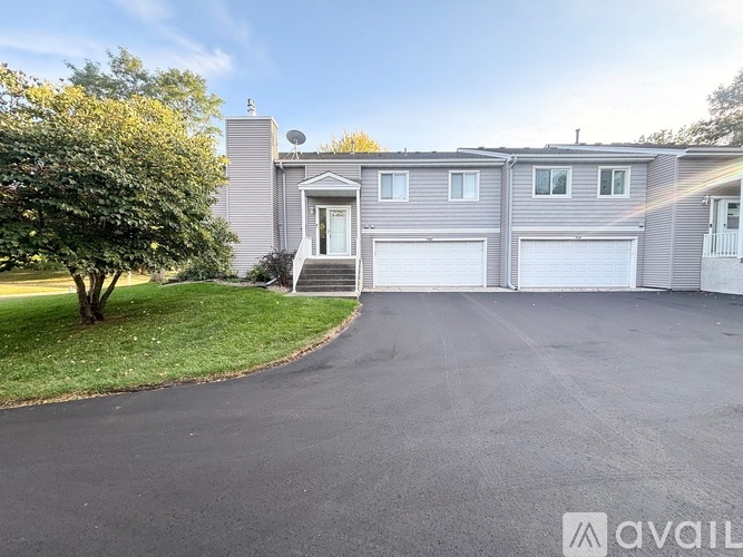 A house with a grey exterior and a tree in front of it.