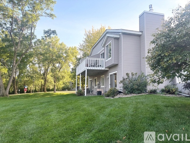 A house with a well-maintained lawn and trees in the background.
