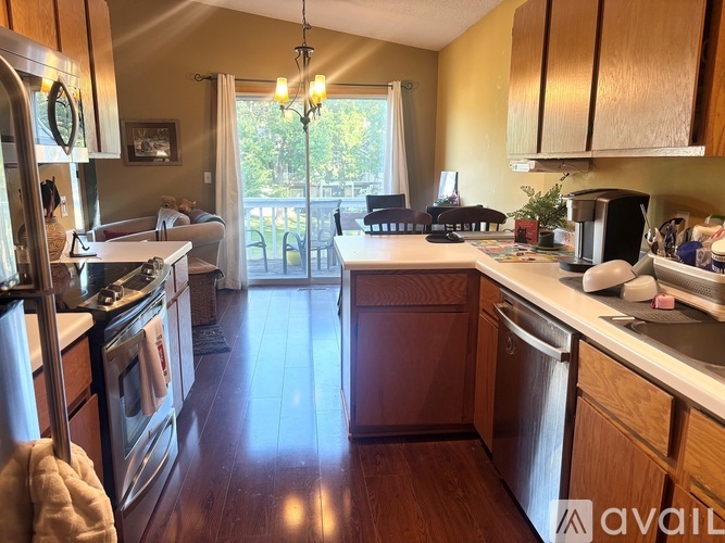 A kitchen with wooden cabinets and a stainless steel dishwasher.