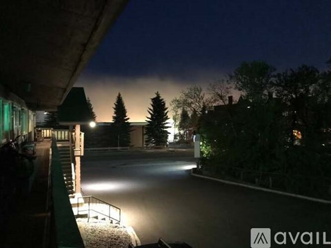 A dark road with street lights and trees on the side.