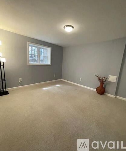 A room with a grey wall and a window.