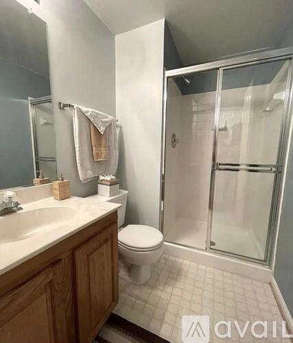 A bathroom with a toilet, sink, and shower.