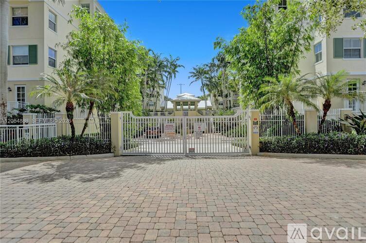 A gated entrance to a residential area with palm trees.