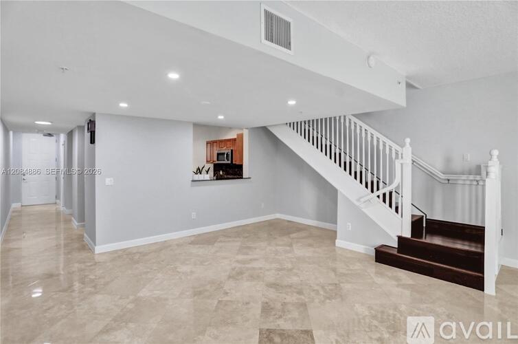 A spacious living room with a staircase leading to the upper floor.