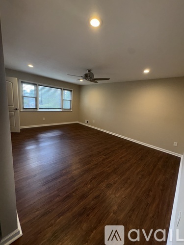 A room with wooden flooring and a ceiling fan.