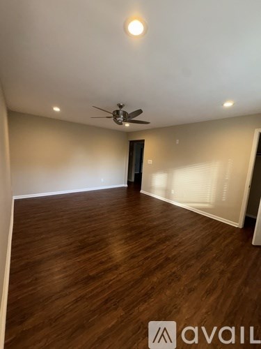 A room with wooden flooring and a ceiling fan.