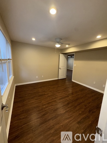 A room with wooden flooring and a ceiling fan.