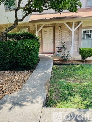 A house with a white door and a small tree in front.