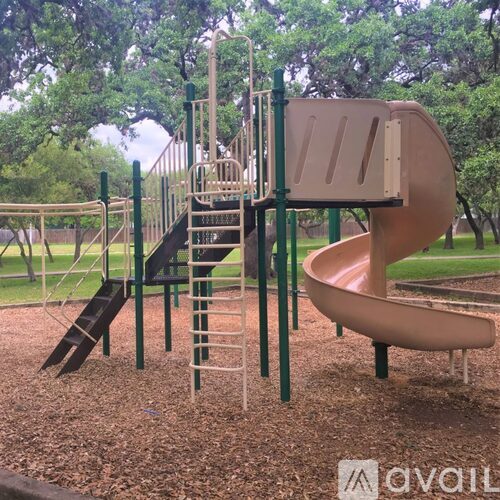 A playground with a slide, a climbing frame and a slide.